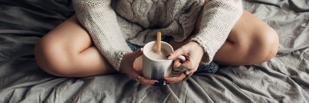 Caucasian woman enjoying a mug of hot coffee in the morning.